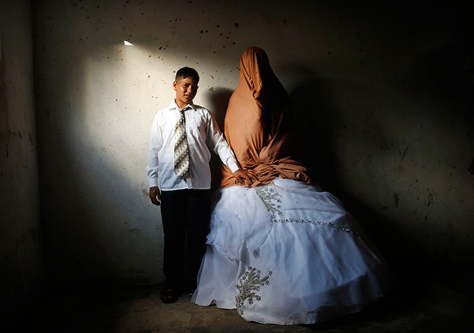 Palestinian groom Ahmed Soboh, 15, and his bride Tala, 14, stand inside Tal